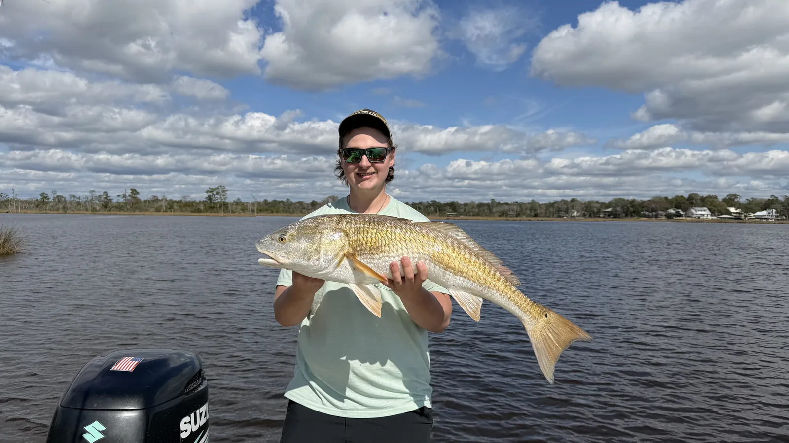 Angler holding redfish catch at Black Creek
