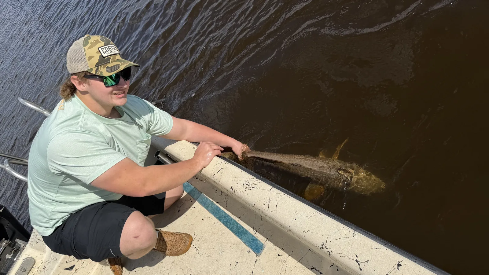 Young angler releasing black drum at Black Creek