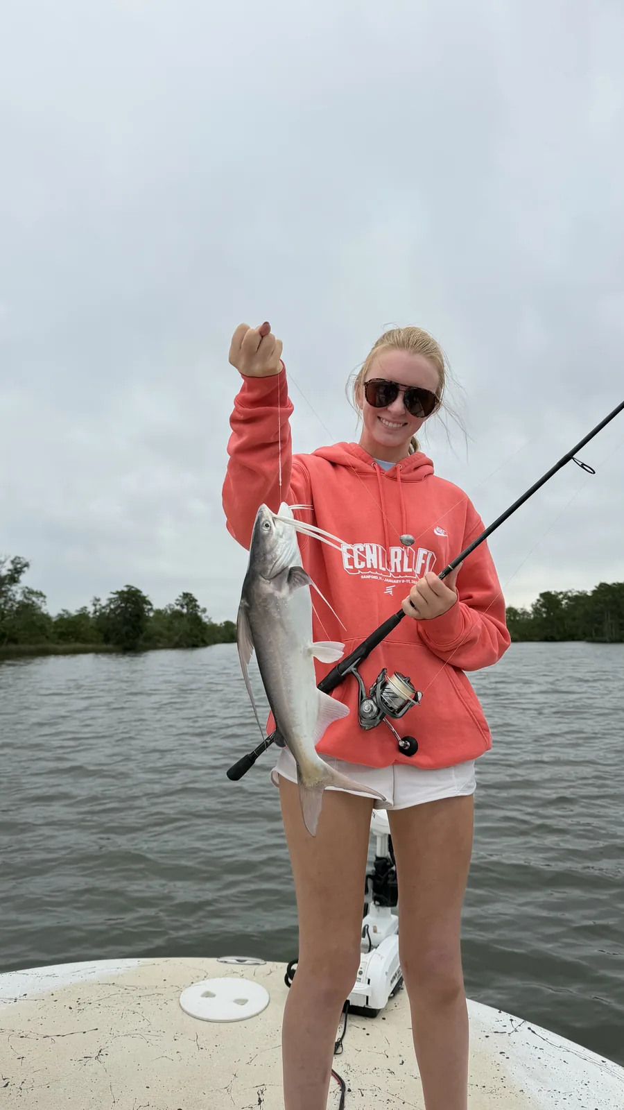 Young woman holding jack crevalle catch on Choctawhatchee Bay