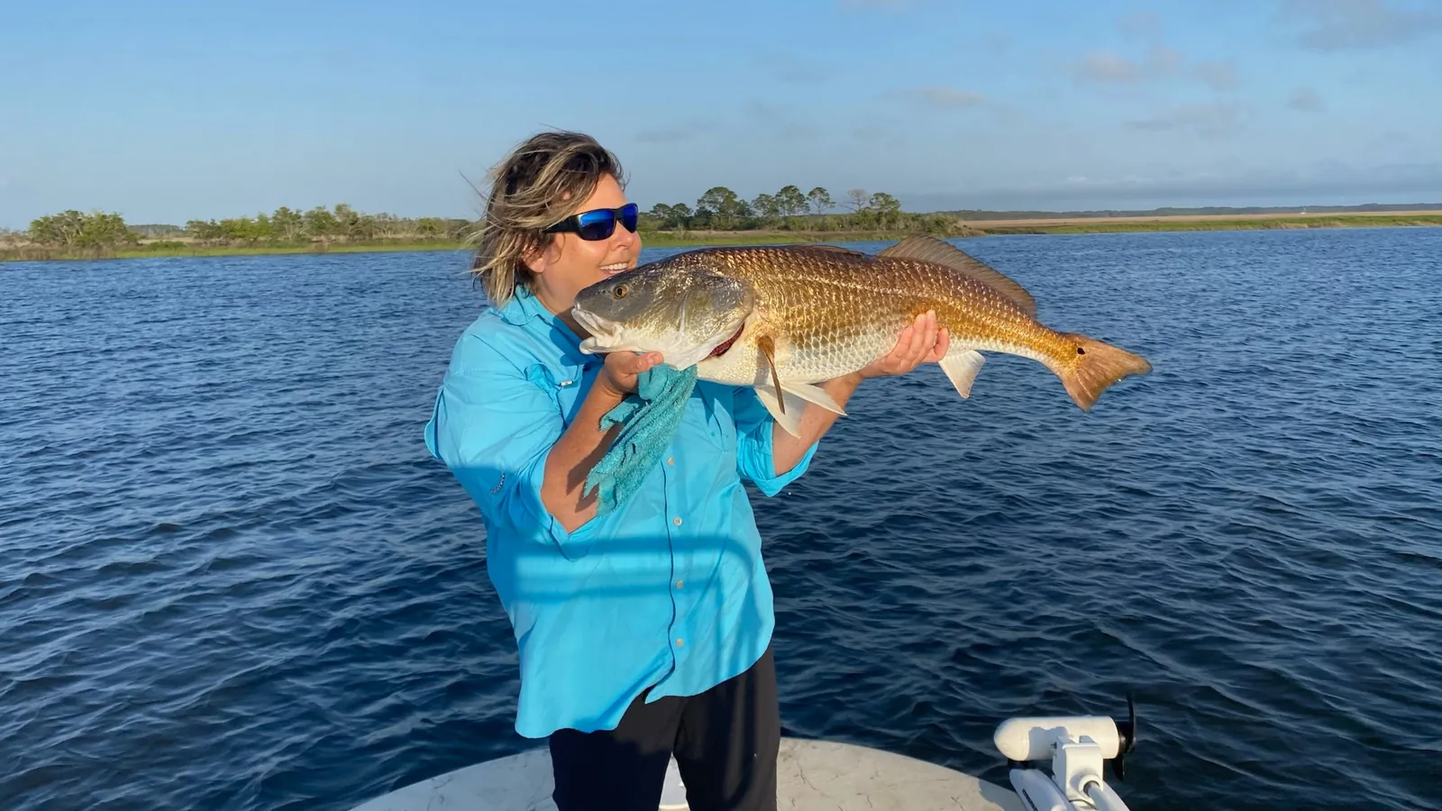 Angler holding large redfish on Choctawhatchee Bay charter